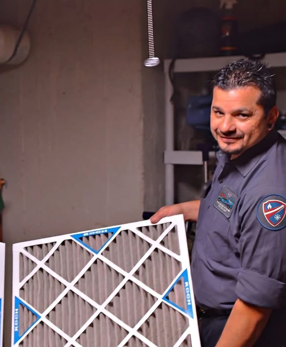 Hero Heating & Cooling technician next to an AC condenser