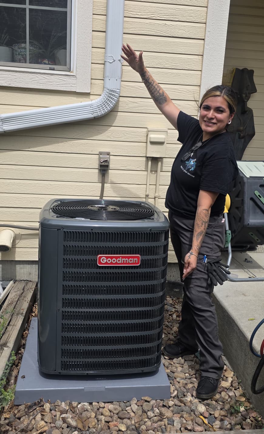 Hero Heating & Cooling technician next to a Goodman AC unit